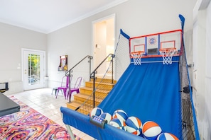 Ein Wohndekor mit Basketballkorb, einer Treppe und einem bunten Teppich.