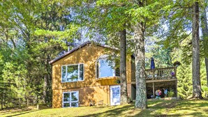 A wooden cabin with two main floors, large windows, and a balcony with outdoor seating. - Outdoor Lover's Paradise w/ Dock & Fire Pit! (Woodruff)