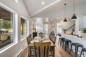 Una cocina moderna con una isla central, iluminación colgante y vistas al exterior.