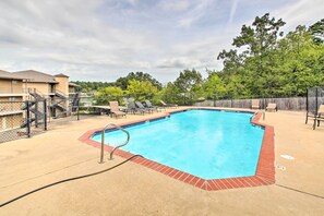 A rectangular pool with a red brick border, surrounded by lounge chairs and a fence. - Balcony & Boat Slip: Lakefront Unit in Hot Springs (Hot Springs)