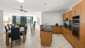 Eine moderne Küche mit Holzschränken, Edelstahlgeräten und einem Essbereich mit Blick.