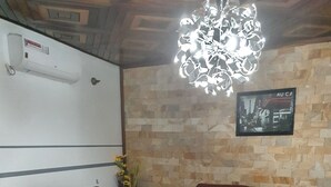 Uma sala de estar com dois sofás de couro, uma mesa de centro branca e um tapete estampado.