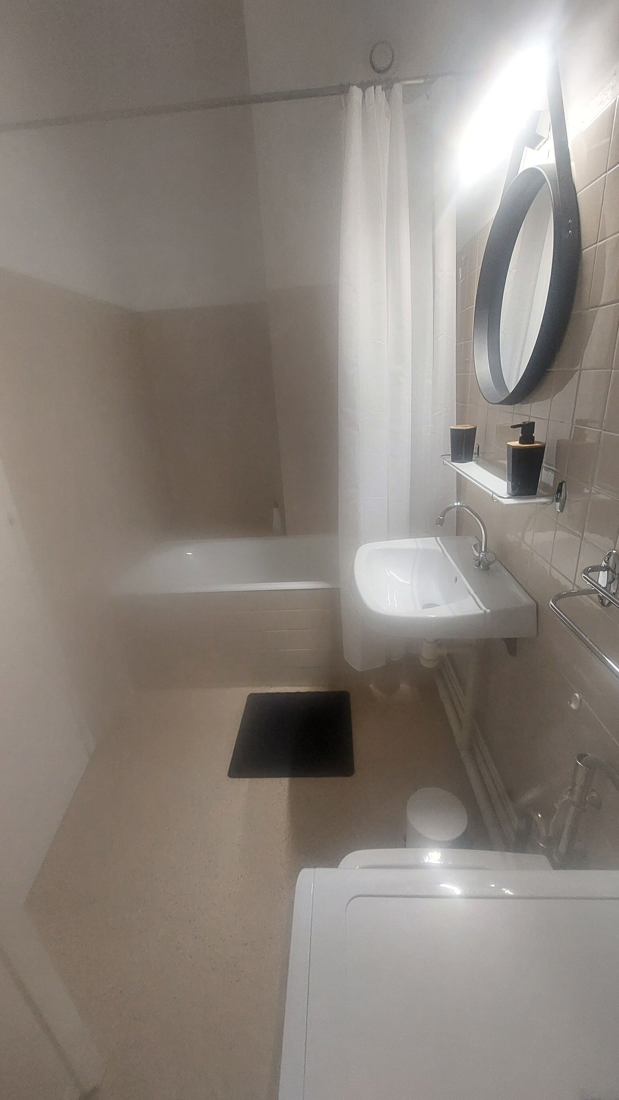 Un baño moderno con bañera, lavamanos y zona de ducha.