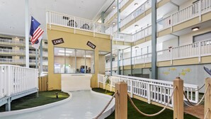 Un atrio a più livelli con piscina, sala giochi e una stanza con la scritta "GAME" e "ROOM".