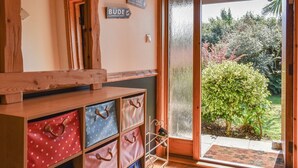 A wooden interior with a sliding glass door leading to a garden. There are signs indicating directions to various locations. - 3 bedroom accommodation in Crackington Haven, near Bude (Crackington Haven, near Bude)