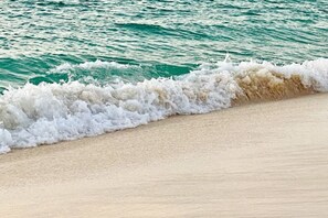 A beach with waves crashing onto the shore.