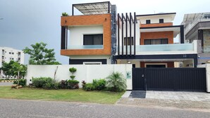 A modern two-story building with a flat roof, a black gate, and a small garden area. - Haven Lodge, 7BR stylish holiday home with hot tub & mountain view (Islamabad)