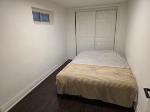 A bedroom with a bed, a window, and a closet. - Walk-out Basement Apt. 1 bedroom+den. Free parking (Thornhill)