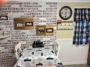 Una habitación rústica con pared de ladrillo, un reloj y decoración de temática campestre.