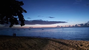 Una playa con cielo despejado y mar tranquilo.