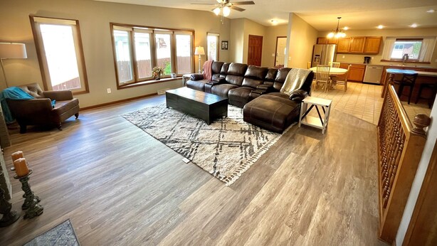 A spacious living room with a sectional sofa, a coffee table, and a dining area with chairs and a table. - The Akes house is a great place to relax and let all your aches fade away.  (Cheyenne)