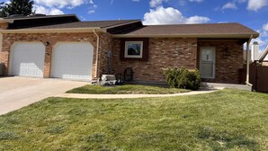 A two-story house with a brick facade, two attached garages, and a well-maintained lawn. - The Akes house is a great place to relax and let all your aches fade away.  (Cheyenne)