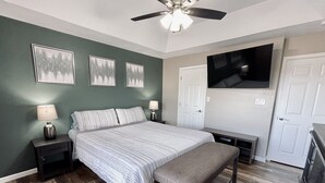 A bedroom with a bed, bedside tables, a bench, a ceiling fan, and a TV mounted on the wall. - ABQ Home Overlooking Mountain- Near Sandia Tramway + Balloon Fiesta  (Albuquerque)