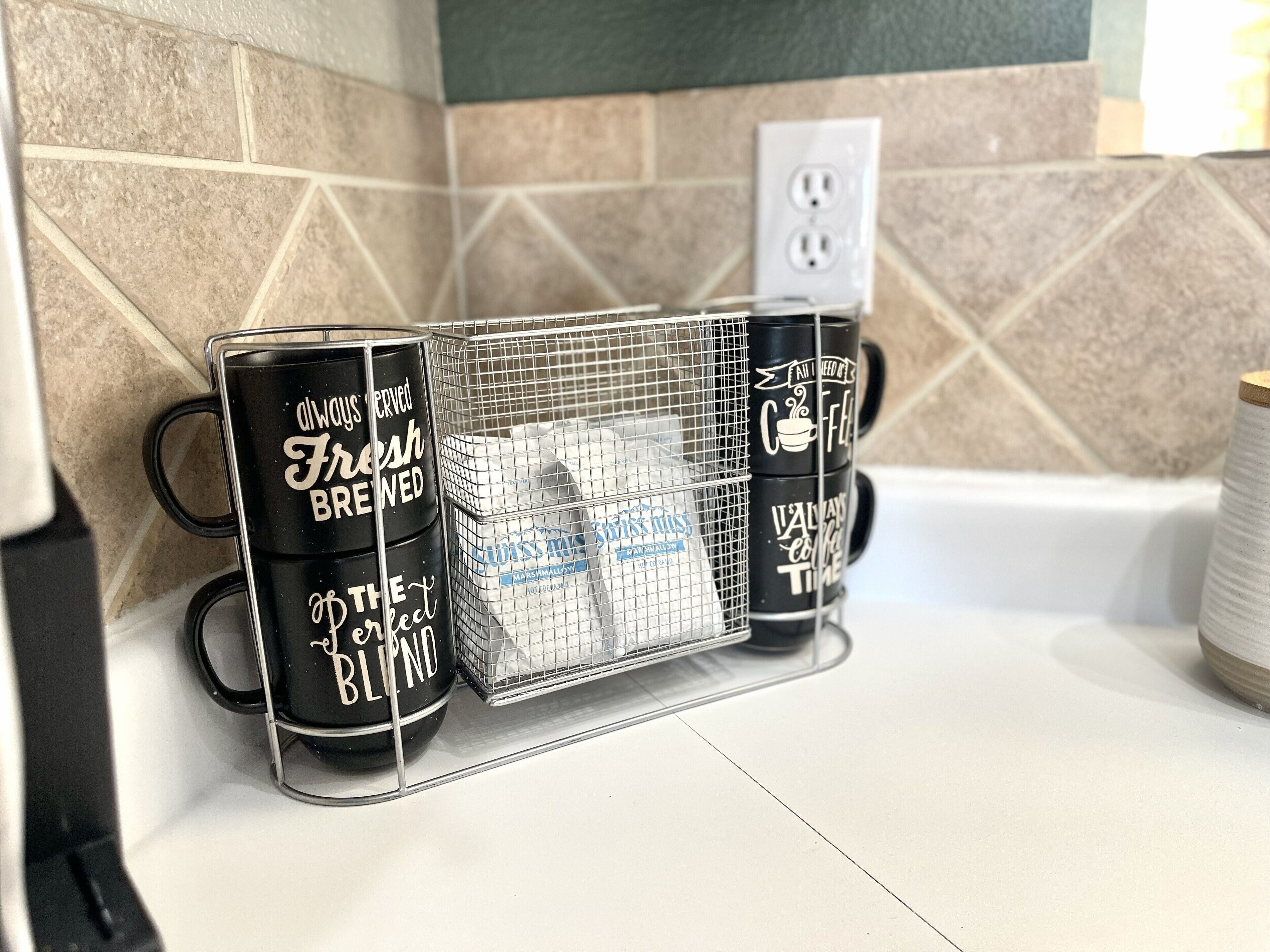 Eine Küchenarbeitsplatte mit Kaffeemaschine, Kaffeemühle und einem Siebkorb für Kaffeebohnen.