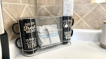 Eine Küchenarbeitsplatte mit Kaffeemaschine, Kaffeemühle und einem Siebkorb für Kaffeebohnen.