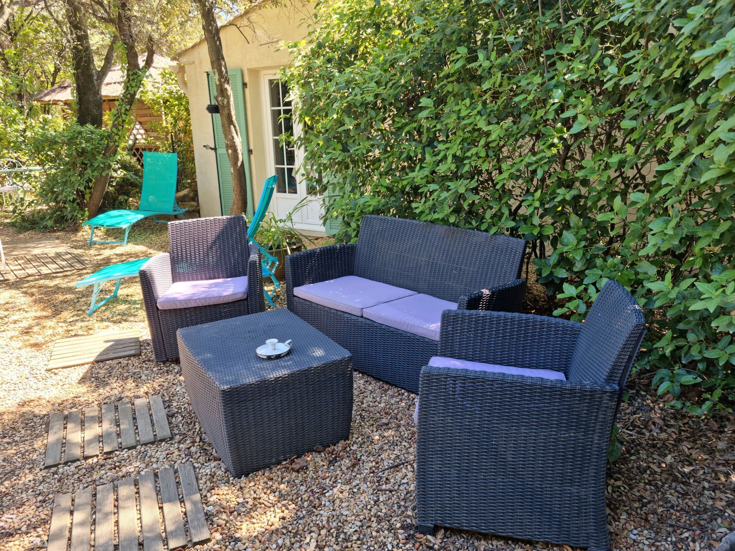 Een terras met rieten meubels en een kleine tafel.
