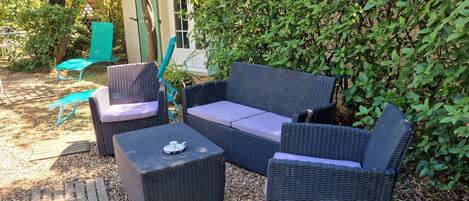 Een terras met rieten meubels en een kleine tafel.