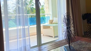 A room with a glass table, a remote control, and a decorative item on the table. - Caribbean style villa directly on the beach (Cabarete)