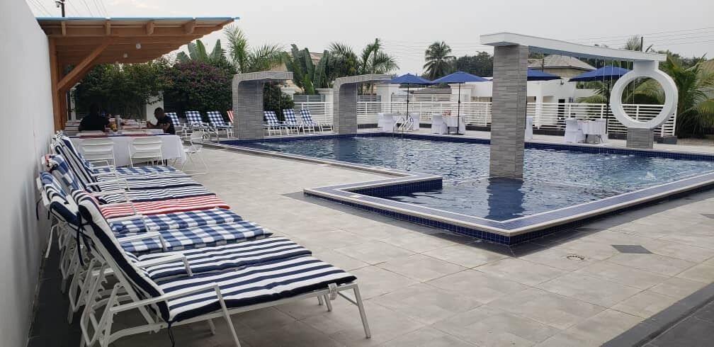 A pool area with lounge chairs and a separate swimming pool.