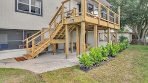 A two-story wooden deck with a metal railing, a number 3508 sign, and a view of the house's exterior. - Modern farmhouse cottage (Okeechobee)