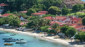 A coastal town with houses, boats, and a beach. - Villa Rackam, balcony on the Baie des Saintes with pool and 300m from beaches (Terre-de-Haut)