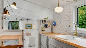 A compact kitchen with a wooden countertop, a white sink, and a built-in refrigerator. - Amazing home in Gilleleje with sauna (Gilleleje)