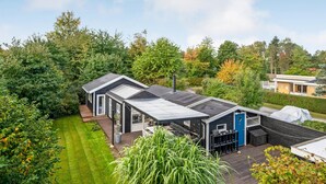 A modern house with a large deck, a covered outdoor area, and a well-maintained garden. - Amazing home in Gilleleje with sauna (Gilleleje)