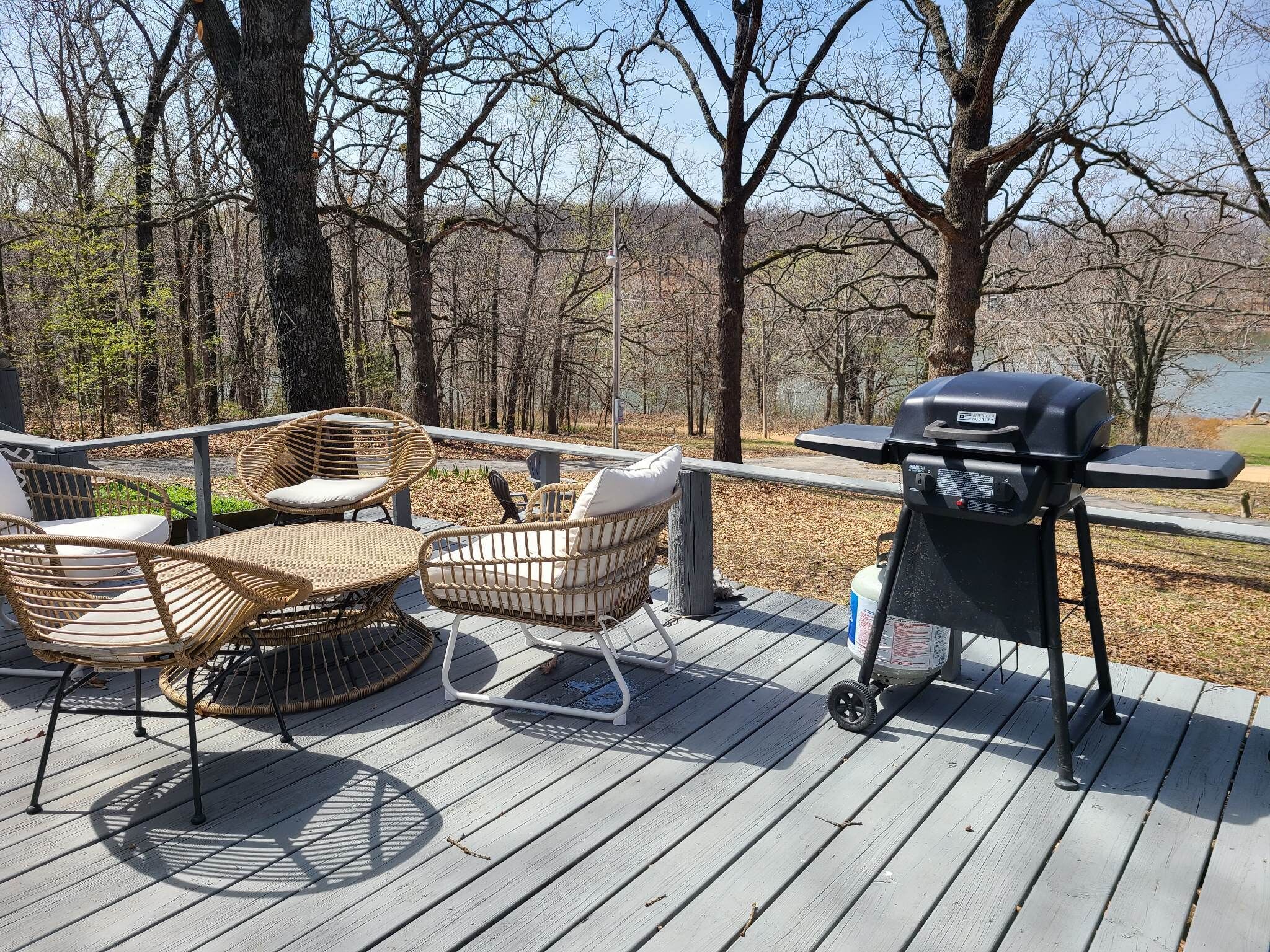 Terraza con mobiliario de mimbre y una parrilla portátil.