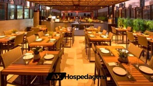 Un restaurante con techo de madera y mesas dispuestas para comer.