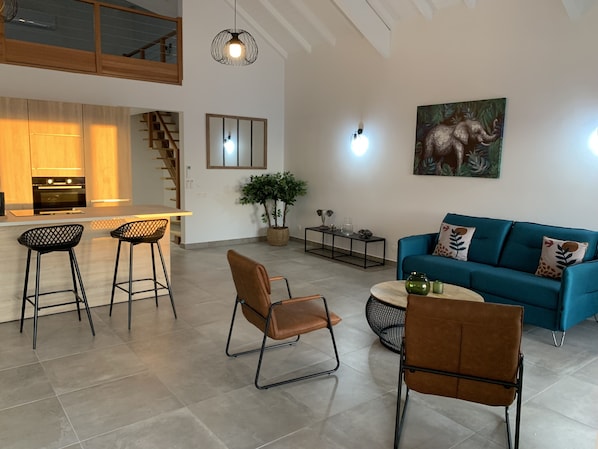 A modern living space with a kitchen, dining area, and seating area.