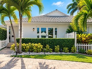 A two-story house with a tiled roof, white exterior walls, and a white picket fence. - Best Location Ever! Comfortable, Cozy and Clean 2bed/2bth (Delray Beach)