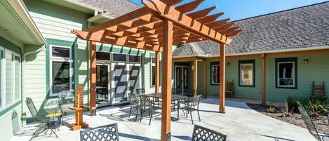 A covered patio area with outdoor seating and a pergola structure.
