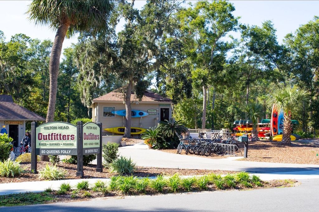 Un petit bâtiment sur lequel est apposée une enseigne indiquant « Hilton Head Outfitters », et qui propose des vélos, des kayaks et du matériel de pêche.