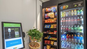 A self-service checkout area with a digital payment terminal, snack vending machine, and a beverage dispenser. - Fully Furnished Style 2 BHK - 1 BATH Apt in San Diego Poway-Miramar with Parking (Poway)
