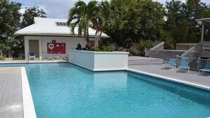 A rectangular swimming pool with a white border, surrounded by a wooden deck.