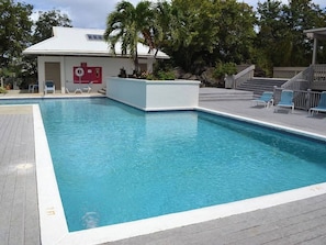 A rectangular swimming pool with a white border, surrounded by a wooden deck. - Ocean Views | Near Magen’s Bay w/ Pool & Generator (Northside)