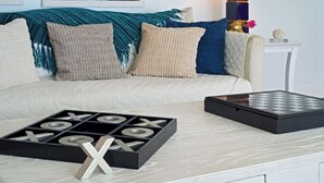 A living room with a sofa, a coffee table, and a board game.