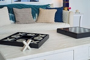 A living room with a sofa, a coffee table, and a board game. - Ocean Views | Near Magen’s Bay w/ Pool & Generator (Northside)