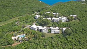 An aerial view of a resort with multiple buildings, a swimming pool, and lush greenery. - Ocean Views | Near Magen’s Bay w/ Pool & Generator (Northside)