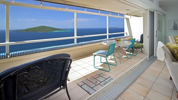 A balcony with a view of the sea, a round table with chairs, and a sofa. - Ocean Views | Near Magen’s Bay w/ Pool & Generator (Northside)