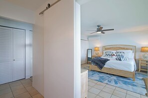 Ein Schlafzimmer mit einem Bett, Nachttischlampen, einem Deckenventilator und einem Kleiderschrank.