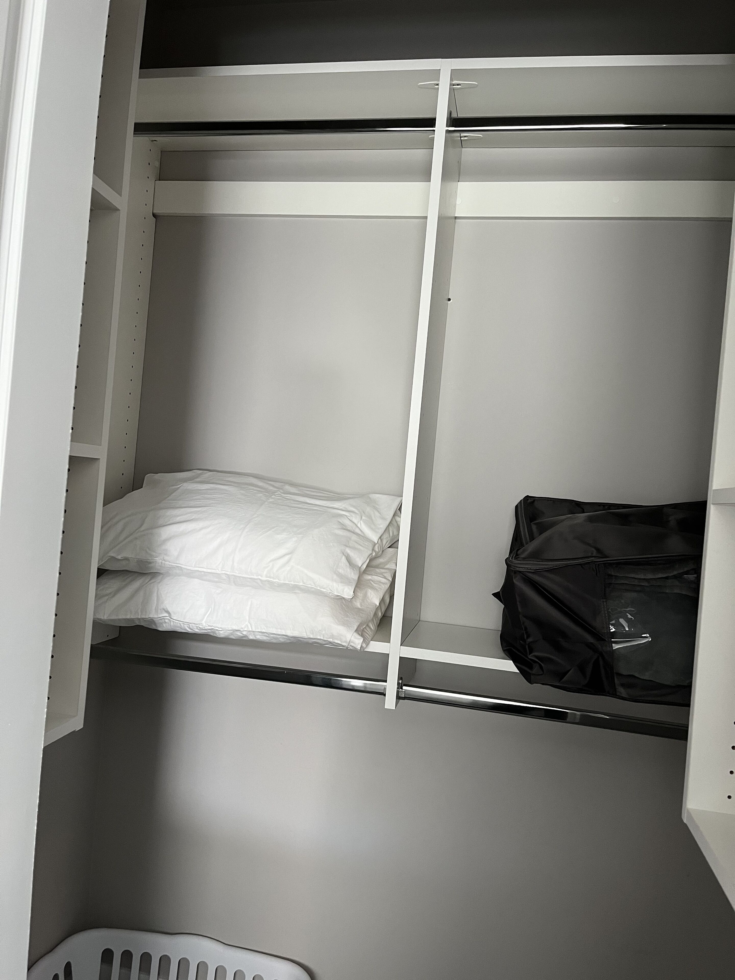 A bunk bed with a white mattress and a black bag hanging on the side.