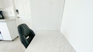 A room with a white desk, a black office chair, and a white door. - Ocean View 1 BR w/Office, Rooftop and Gardens (Playas del Coco)