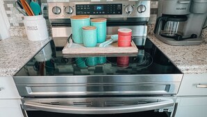 A kitchen with a stainless steel stove, a Keurig coffee maker, and a container of utensils. - Clean, Modern Cottage near Martinsville! (Fieldale)