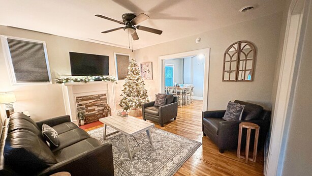 A living room with a fireplace, a Christmas tree, and a ceiling fan. - Clean, Modern Cottage near Martinsville! (Fieldale)