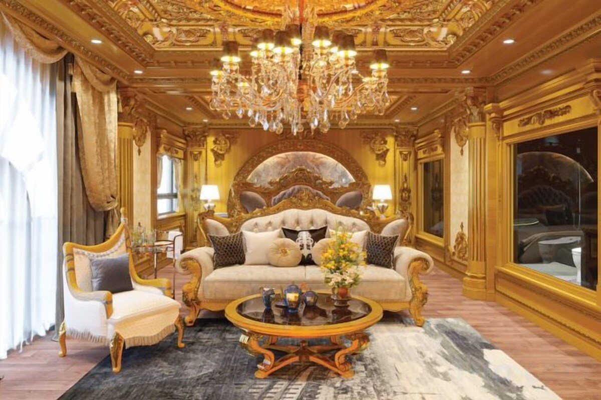 A luxurious room with a large ornate bed, a chandelier, and a classic design.