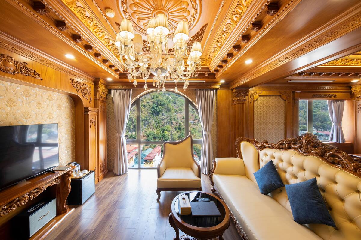 A luxurious room with a large television, a sofa, a chair, and a coffee table.
