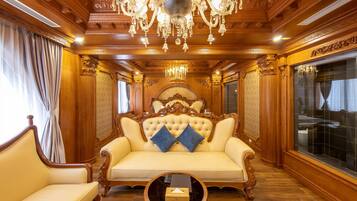 Um quarto luxuoso com uma cama grande, teto de madeira decorado e um candelabro.