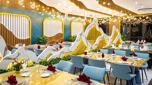 A restaurant with multiple dining tables, blue chairs, and a modern interior design. - Glenda Tower Moc Chau Hotel (Moc Chau)