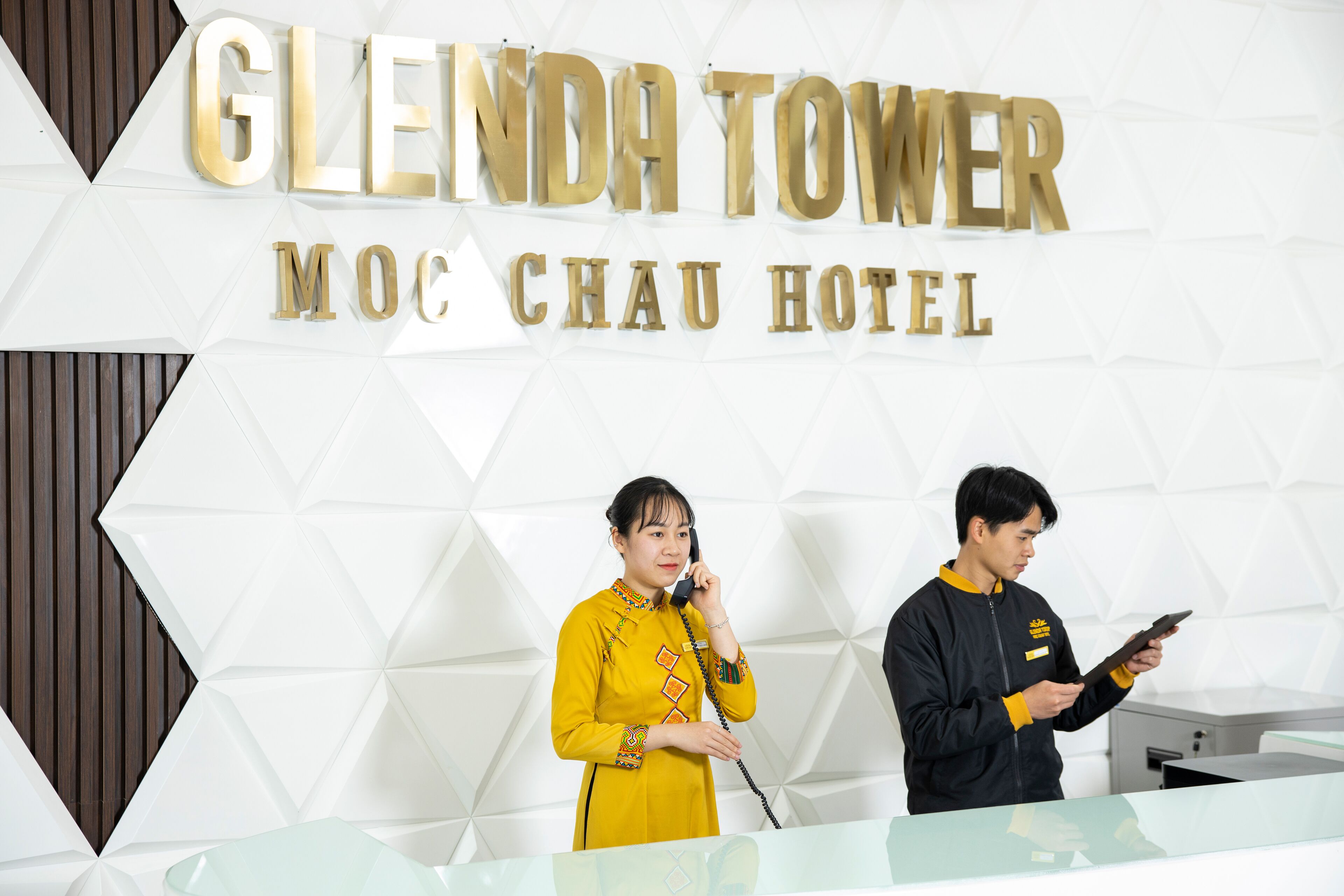 A reception desk with a sign reading 'GLENDA TOWER MOC CHAU HOTEL'.